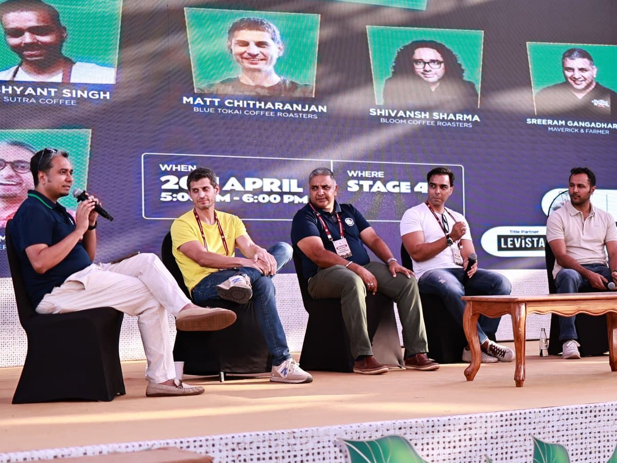 A moderator and panellists on stage at a festival panel discussion